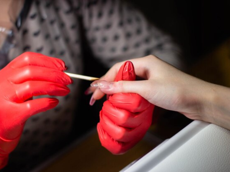 Aplicando gel UV para alongamento de unhas.