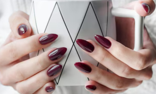 Mãos femininas com unhas alongadas em gel, destacando um acabamento impecável e moderno.